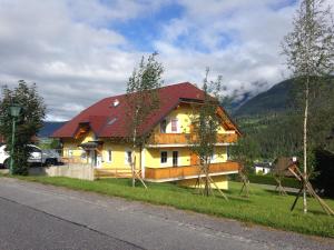 dom z czerwonym dachem przy drodze w obiekcie Appartement Zirkl / Haus Gloria w mieście Haus im Ennstal