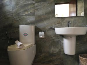 a bathroom with a toilet and a sink at Pick & Go White House in Negombo +63 photos