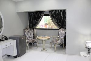 um quarto com uma mesa e cadeiras e uma janela em White Fort Hotel em Dubai