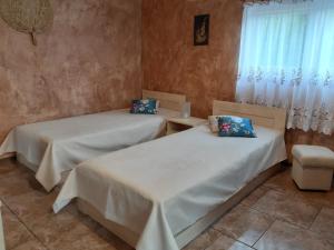 two beds in a room with a window at Pensjonat U Kasi in Węgorzewo