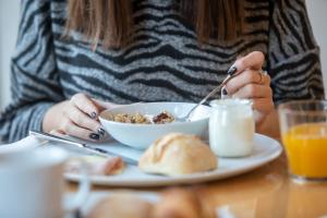 a woman sitting at a table with a bowl of food at Stay Hotel Faro Centro in Faro