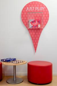 a table and a red stool and a sign that says just play at Stay Hotel Faro Centro in Faro
