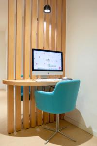 a computer sitting on a desk with a blue chair at Stay Hotel Faro Centro in Faro