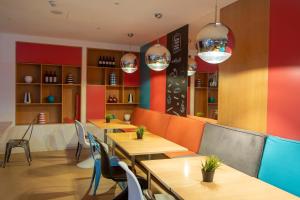 a restaurant with tables and chairs and colorful walls at Stay Hotel Faro Centro in Faro