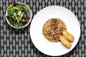a white plate with a salad and a bowl of food at Stay Hotel Faro Centro in Faro