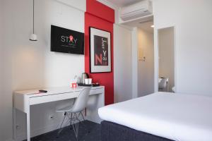 a bedroom with a desk and a bed and a desk and chair at Stay Hotel Faro Centro in Faro