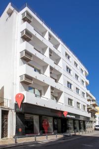 a tall building with a red and white building at Stay Hotel Faro Centro in Faro