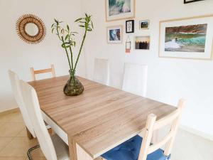 a dining room table with a vase with flowers in it at Casa Mawi in Sagres +23 photos