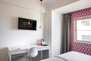 a room with a bed and a desk and a window at Stay Hotel Faro Centro in Faro