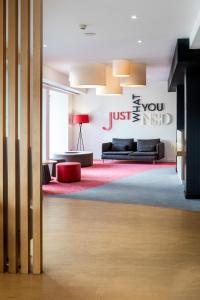 a living room with a couch and a red rug at Stay Hotel Faro Centro in Faro