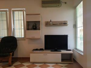 a living room with a television on a table with a chair at Green Apartman in Rafailovici
