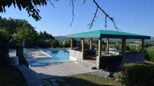 una piscina con cenador, mesa y piscina en Country House Daniela, en Fano