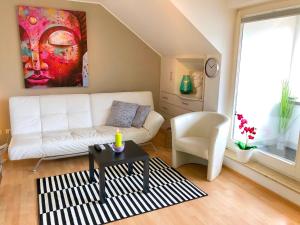 ein Wohnzimmer mit einem weißen Sofa und einem Tisch in der Unterkunft FeWo Seeperle mit Seesicht in Bodman-Ludwigshafen