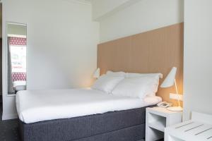 a bedroom with a bed and a nightstand with a phone at Stay Hotel Faro Centro in Faro +37 photos