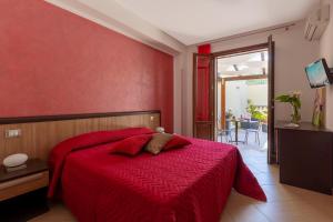 カステッルッツォにあるBed&Breakfast Acasamiaの赤い壁のベッド付きの赤いベッドルーム