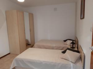 two beds in a room with white sheets at Pensjonat U Kasi in Węgorzewo