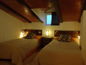 a bedroom with two beds and a window at Casa Rural Recreo in El Gastor +55 photos