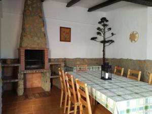 a dining room with a table and a fireplace at Casa Rural Recreo in El Gastor