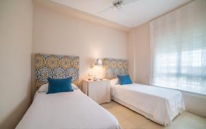 deux lits dans une petite pièce avec une fenêtre dans l'établissement Apartamento con vistas al mar, à Santiago de la Ribera