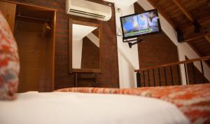 a bedroom with a bed with a tv on the wall at El Paso departamentos in San Juan