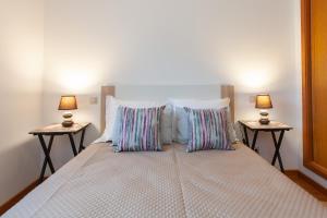 una camera con un letto con due lampade su due tavoli di Casas Ponte D'Alge a Foz de Alge