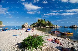 pessoas em uma praia com barcos na água em Salu’ em Taormina