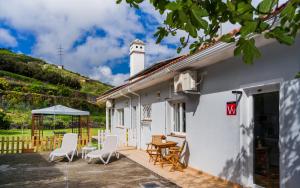 a white house with a patio with chairs and a table at Estudio rural - Nature & Relax in La Orotava