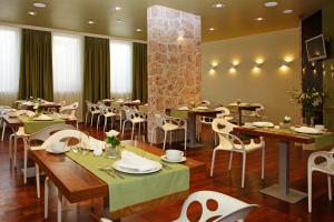 a restaurant with wooden tables and white chairs at Boutique Hotel Bol in Bol