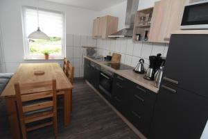 eine Küche mit einem Holztisch und eine Küche mit einem Esszimmer in der Unterkunft Ferienhaus kleine Villa in Marschkamp