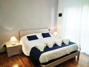 a bedroom with a large bed with white sheets and blue pillows at Domus al Parco Guest House in Fiumicino