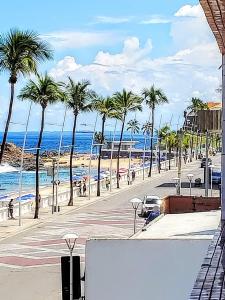 a view of a beach with palm trees and the ocean at Flat Na Barra in Salvador