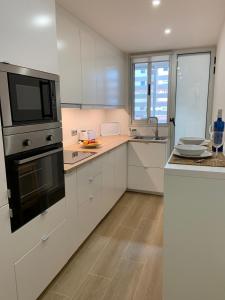 una cocina con armarios blancos y un aparato negro en Mi Nido, en Santa Cruz de la Palma