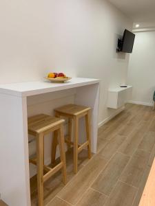 a kitchen with a white counter and stools at Mi Nido in Santa Cruz de la Palma