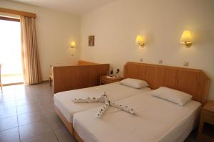 een hotelkamer met 2 bedden en een raam bij LINDOS HORIZON in Lindos