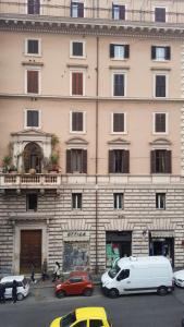 un grand bâtiment avec des voitures garées devant lui dans l'établissement Duca di Cavour, à Rome