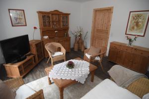 ein Wohnzimmer mit einem Tisch, Stühlen und einem TV in der Unterkunft Ferienhaus kleine Villa in Marschkamp