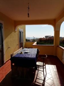 Zimmer mit einem Tisch und Stühlen sowie einem großen Fenster in der Unterkunft Aria Di mare in San Nicola Arcella