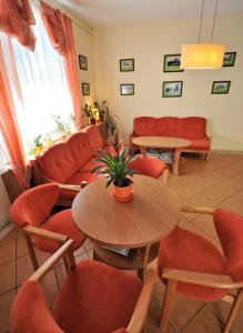 a waiting room with tables and chairs and a couch at Pensjonat Fala in Ustronie Morskie