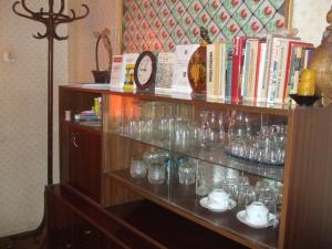 a shelf filled with glasses and books and a clock at Daneto Rooms in Targovishte +7 photos