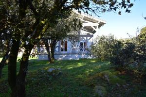 a white house with trees in front of it at Le Chalet du Moulin in Brousses-et-Villaret