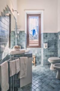 聖帕特雷拉的住宿－B&B Da Nicoletta，蓝色瓷砖浴室设有水槽和卫生间