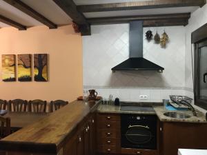 a kitchen with a stove and a counter top at CASA RURAL LA IBIENZA in Zarzuela del Pinar