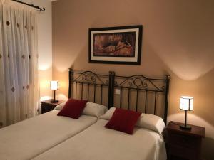 1 dormitorio con 2 camas y almohadas rojas en CASA RURAL LA IBIENZA, en Zarzuela del Pinar