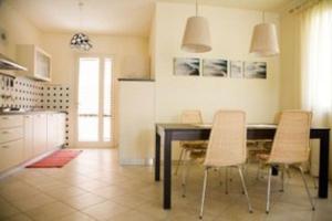 - une cuisine avec une table à manger et des chaises dans l'établissement VILLETTA CON GIARDINO, à Lido di Camaiore