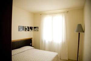 una camera con letto, finestra e lampada di VILLETTA CON GIARDINO a Lido di Camaiore