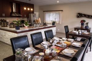 a dining room with a table and a kitchen at Haus Mopanie in Tsumeb