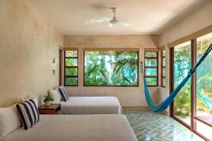 Postel nebo postele na pokoji v ubytování Hotel Tiki Tiki Tulum + 37 fotografií
