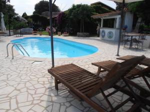 a swimming pool with two chairs and an umbrella at Casa Alianda in Telti