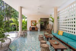 a lobby with a blue couch and tables and chairs at Hotel Tiki Tiki Tulum in Tulum