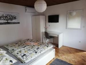 um pequeno quarto com uma cama e uma secretária em Sobe Zimmer Rooms Nika em Tušilović